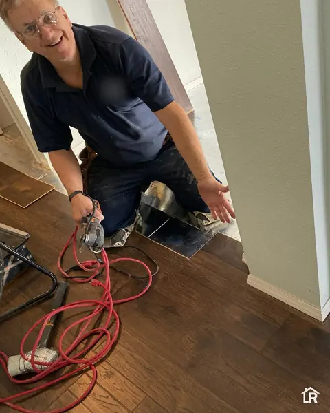 Sandro Rauen installing a wood floor